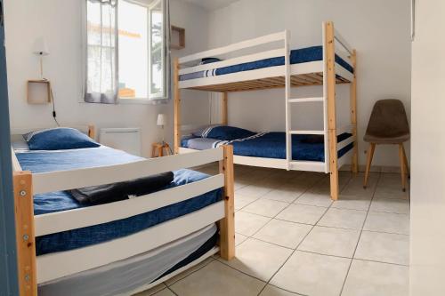 a room with two bunk beds and a desk at maison 300m mer à Brétignolles-sur-Mer (La Parée)- Calme in Brétignolles-sur-Mer