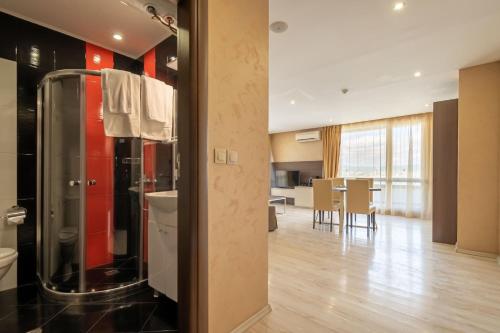a bathroom with a shower and a dining room at Paradiso Dreams Hotel in Nesebar