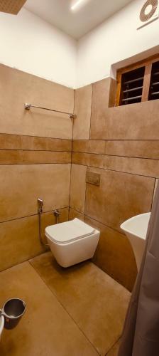a bathroom with a white toilet and a sink at Grandstaykannur in Kannur