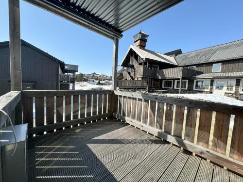 Eine Holzterrasse mit einem Haus im Hintergrund in der Unterkunft Family-friendly apartment for rent at Golsfjellet in Golsfjellet