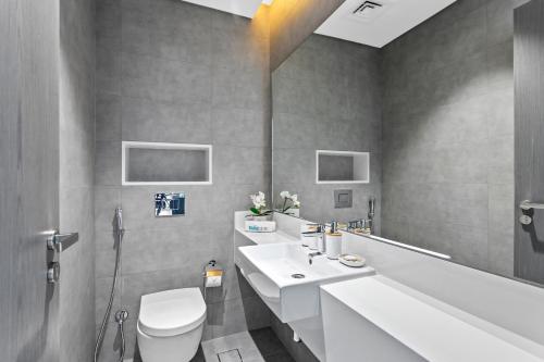 a bathroom with a white sink and a toilet at Premium 1-BR with Exquisite Layout in District One in Dubai