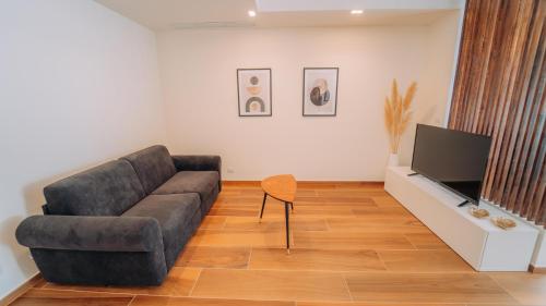 a living room with a couch and a flat screen tv at Donna Concetta seaside apartment in Giardini Naxos