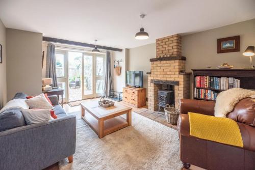 a living room with two couches and a fireplace at The Coach House, Reydon in Reydon