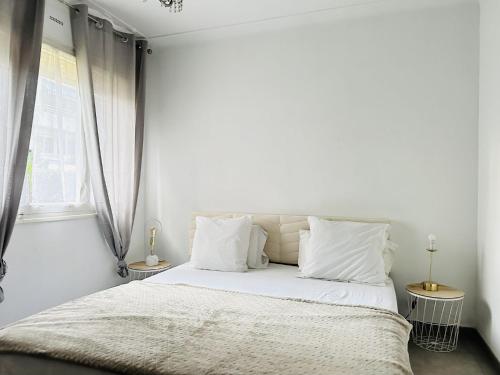 une chambre blanche avec un lit avec des draps et des oreillers blancs dans l'établissement Le Cirodde - Grande terrasse - Centre Cannes -Clim, à Cannes