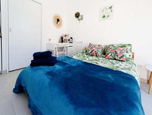 a bedroom with a bed with a blue blanket at Gite Le Cocon de Lily in Saint-Savin-de-Blay