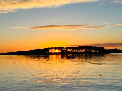 a sunset over a lake with a boat in the water at Casa Sasa in Porto Cesareo