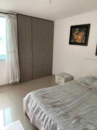 sypialnia z dużym łóżkiem i oknem w obiekcie Playa Salguero Condominio Aragoa w mieście Puerto de Gaira