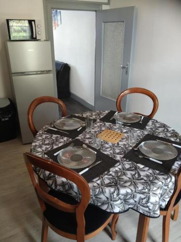 a dining room table with plates and glasses on it at Saturne in Fourchambault