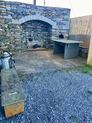 a stone bench in front of a stone fireplace at Clarefornia Stone Shed in Lahinch