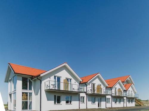 a row of houses with orange roofs at Lydinge Resort in Hyllinge