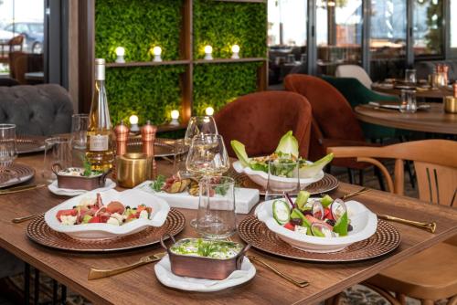 a wooden table with plates of food on it at Paradiso Dreams Hotel in Nesebar