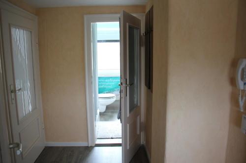 a bathroom with a door open to a bathroom with a toilet at Ferienwohnung ELPIDA in Rodewisch