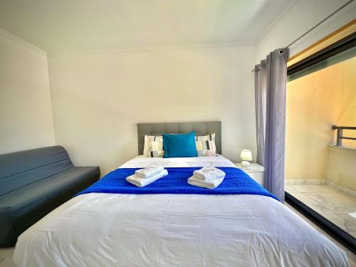 a bedroom with a large bed with blue pillows at Vilamoura Prestige 2 With Pool by Homing in Vilamoura
