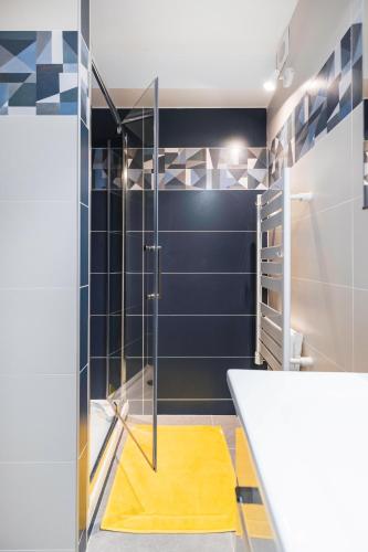 La salle de bains est pourvue d'une douche et d'un tapis jaune. dans l'établissement Spacieux appart pour 6, front de mer, centre, à Le Touquet-Paris-Plage