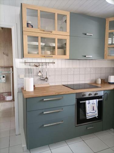 - une cuisine avec des placards bleus et une cuisinière dans l'établissement Villa Nantucket, à Lège-Cap-Ferret