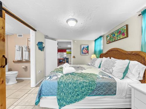 a bedroom with a large bed and a bathroom at Family Tides Steps to beach and bay in Bradenton Beach