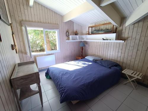 une chambre avec un lit bleu et une fenêtre dans l'établissement Villa Nantucket, à Lège-Cap-Ferret