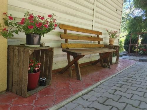 a wooden bench sitting on a patio with potted plants at Gościniec pod Skółką in Łącko
