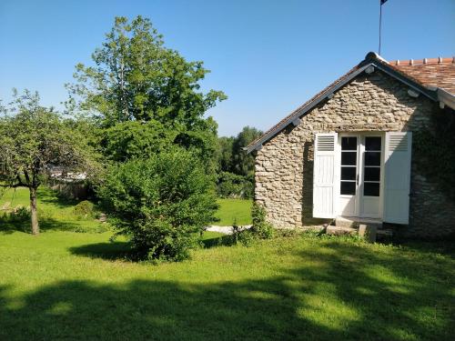 an old stone building with a window and a tree at Le Clos Ste Thérèse by Idylliq 