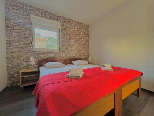 a bedroom with a large bed with a red blanket at Apartments Villa Rotim in Zadar