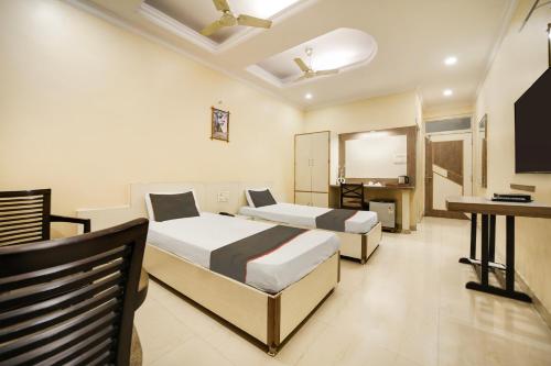 Habitación de hotel con 2 camas y TV de pantalla plana. en Collection O Hotel Silver Inn, en Bhopal