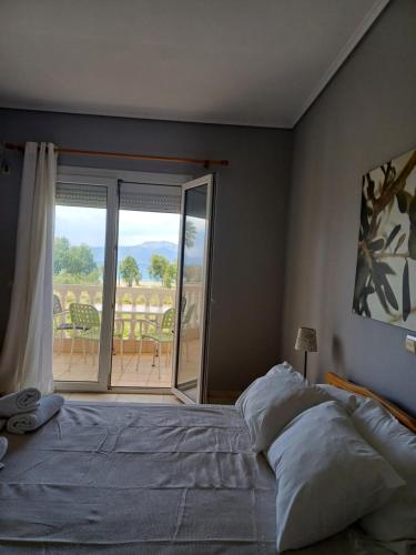 a bedroom with a bed and a view of a balcony at Aktaion apartments in Artemísion