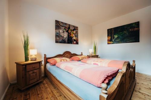 sypialnia z 2 łóżkami i 2 zdjęciami na ścianie w obiekcie Ferienwohnung Gitte w mieście Schneverdingen