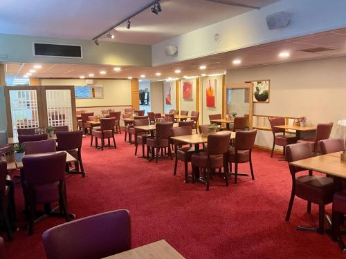 a restaurant with tables and chairs in a room at Britannia Inn Glasgow in Glasgow