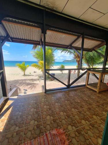 an open room with a view of the beach at Rainbow Tioman Cottage in Kampong Juara