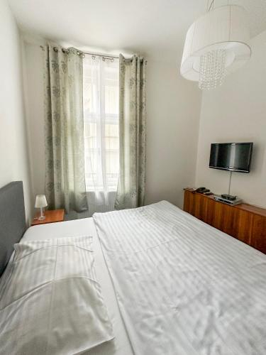 a white bed in a bedroom with a window at Hotel Růžek in Hranice