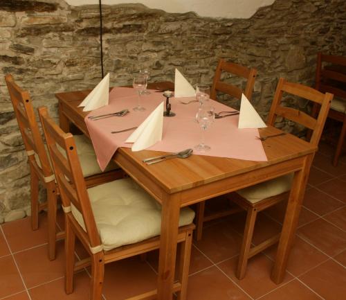 a wooden table with wine glasses and napkins on it at Hotel Růžek in Hranice