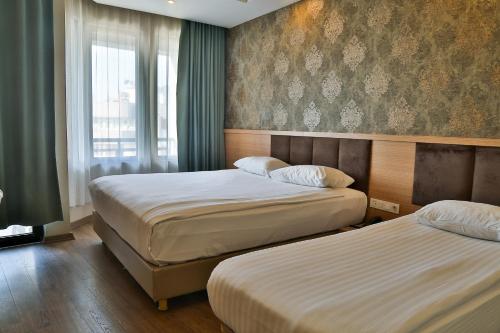 Habitación de hotel con 2 camas y ventana en Start Hotel, en Antalya
