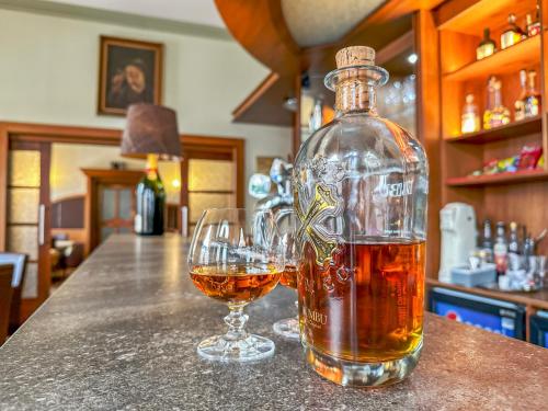 a bottle of whiskey and two glasses on a counter at Hotel Růžek in Hranice