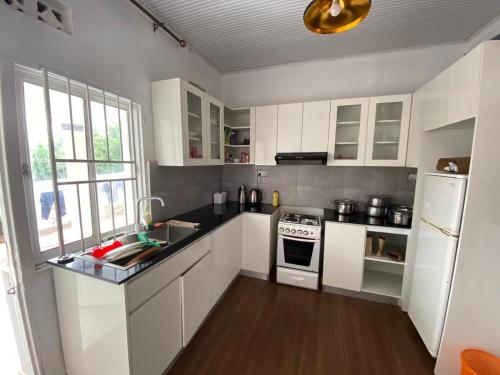 una cocina con armarios blancos y un horno de fogón blanco en BIZI HOMES en Kigali