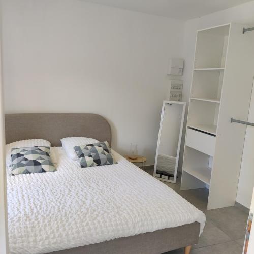 a bedroom with a bed with two pillows on it at Côté Verdon in Quinson