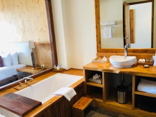 a bathroom with a large tub and a sink at The Postcard Dewa, Thimphu, Bhutan in Thimphu