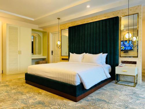 um quarto com uma cama grande e uma cabeceira verde em Devon Rest em Kandy