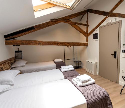 a room with three beds and a ceiling with beams at ISSA Lesvos in Mytilini