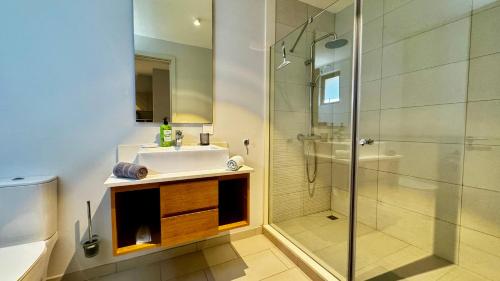 un baño con lavabo y ducha en Luxury Beachfront Apt - Perfect for Beach Lovers, en Rivière Noire