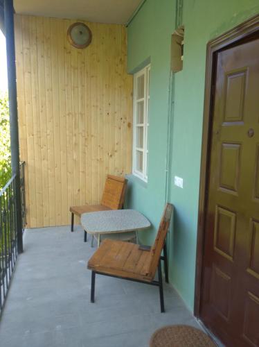 a porch with two chairs and a table and a door at ТИФАНИ - дом с бассейном у речки in Bjni