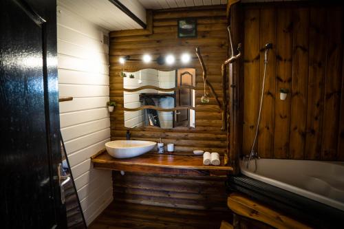 Habitación de madera con baño con lavabo. en Les Hébergements au Dy-Na en Petite Île