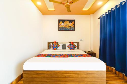 Schlafzimmer mit einem großen Bett und blauen Vorhängen in der Unterkunft FabHotel Roadside Inn in Naksalbāri