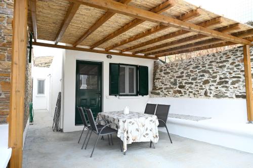 een tafel en stoelen op een patio met een houten plafond bij Simousi Studio 1, On the Beach! Kythnos in Kithnos