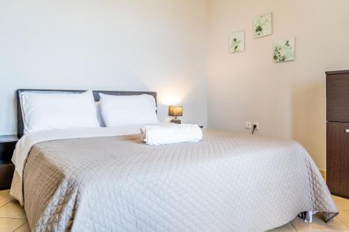 um quarto com uma cama grande e uma colcha branca em Koroni Family house with the best view 84 sqm em Koroni