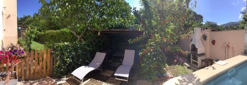 une cour avec des chaises, une clôture et des arbres dans l'établissement Entre Mer et Montagnes, à Céret