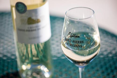 a glass of wine next to a bottle of wine at Château Saint-Pierre de Mejans in Puyvert