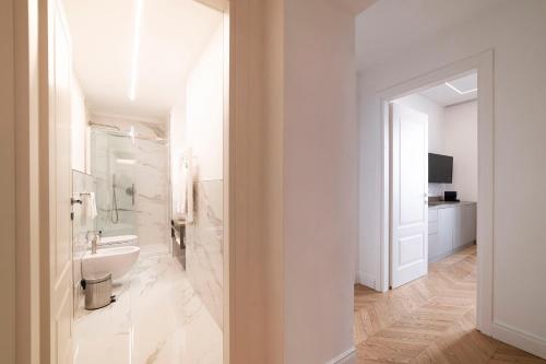 a white bathroom with a sink and a toilet at Buenos Aires 58 in Milan