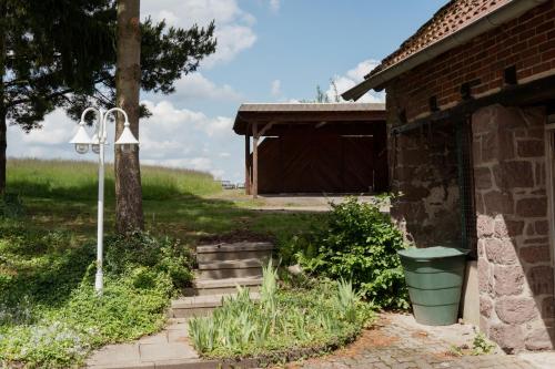 a brick house with a trash can next to a building at Idyllische Ferienwohnung im Kalletal in Kalletal