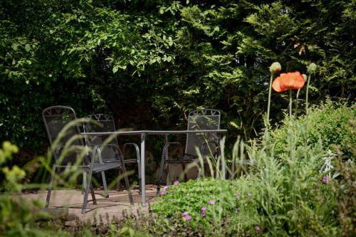 two chairs sitting on a table in a garden at Idyllische Ferienwohnung im Kalletal in Kalletal