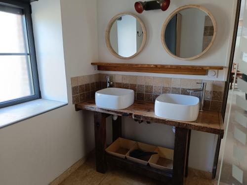 a bathroom with two sinks and two mirrors at gite de la grand maison les chênes in Seigy
